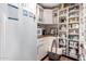 Pantry view showing a well-organized storage space with white shelves, a refrigerator and wooden countertop at 8302 S Jentilly Ln, Tempe, AZ 85284