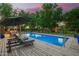 Inviting pool area with lounge chairs, umbrella and cool water at dusk at 8302 S Jentilly Ln, Tempe, AZ 85284