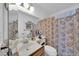 A clean bathroom features a single sink, mirror, vanity lighting, and a shower with a decorative curtain at 919 E Villa Maria Dr, Phoenix, AZ 85022