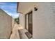 Enclosed patio area with sliding glass door entrance, textured wall, outdoor lighting and a small welcome mat at 919 E Villa Maria Dr, Phoenix, AZ 85022