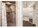 This is an open view of a shower with a seat and the closet with open shelving at 937 N Marble St, Gilbert, AZ 85234