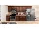 Well-equipped kitchen featuring stainless steel appliances and dark wood cabinets at 937 N Marble St, Gilbert, AZ 85234