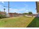 Backyard featuring grass area, surrounded by a partial brick wall, providing space and privacy at 1020 E Concorda Dr, Tempe, AZ 85282