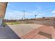 Backyard with a concrete patio and a partial brick wall, offering space for outdoor activities at 1020 E Concorda Dr, Tempe, AZ 85282
