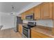A bright kitchen showcases stainless steel appliances, wood cabinets, and stone countertops at 1020 E Concorda Dr, Tempe, AZ 85282