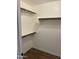 A walk-in closet with slat shelving and wood-look flooring at 1040 W Juniper Ave, Gilbert, AZ 85233
