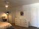 Modern bedroom with a sleek floor lamp, a white dresser, and neutral walls at 1156 E Vinedo Ln, Tempe, AZ 85284