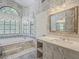 Bathroom featuring large windows, a soaking tub, decorative wallpaper, and a single sink vanity at 13064 N 100Th Pl, Scottsdale, AZ 85260