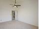 Cozy bedroom with neutral carpet, ceiling fan, and open doorway to bathroom at 13064 N 100Th Pl, Scottsdale, AZ 85260