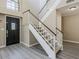 Bright foyer featuring a staircase with white railings, a dark front door, and attractive wood-look floors at 13064 N 100Th Pl, Scottsdale, AZ 85260