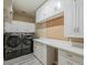 Well-organized laundry room with cabinets, white countertops, and side-by-side washer and dryer at 13064 N 100Th Pl, Scottsdale, AZ 85260