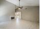 Living room with fireplace, vaulted ceilings, ceiling fan, tile floors, and a hallway at 13064 N 100Th Pl, Scottsdale, AZ 85260