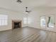 Inviting living room featuring a decorative fireplace and wood-look laminate flooring at 13064 N 100Th Pl, Scottsdale, AZ 85260
