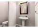 Cozy powder room featuring a pedestal sink, framed mirror, and neutral paint at 13448 W Miner Trl, Peoria, AZ 85383