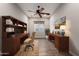Well-lit home office features built-in bookshelves, dual desks, ceiling fan, and neutral color palette at 13448 W Miner Trl, Peoria, AZ 85383