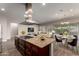 This open-concept kitchen features a granite island with a gas stovetop and a stainless steel range hood at 13448 W Miner Trl, Peoria, AZ 85383