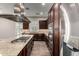 A well-equipped kitchen features dark cabinetry, stainless steel appliances, and an island with a gas stovetop at 13448 W Miner Trl, Peoria, AZ 85383