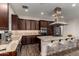 Gourmet kitchen boasts dark wood cabinets, granite countertops, stainless steel appliances, and a central island at 13448 W Miner Trl, Peoria, AZ 85383