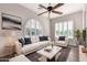 Relaxing living room features plantation shutters, ceiling fan, and plush white sofa with blue pillows at 13448 W Miner Trl, Peoria, AZ 85383
