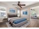 Comfortable main bedroom features modern ceiling fan, gray color palette, and views into the living area at 13448 W Miner Trl, Peoria, AZ 85383