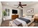 Comfortable main bedroom with plantation shutters, ceiling fan, dresser, and bench at 13448 W Miner Trl, Peoria, AZ 85383