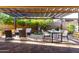 Covered outdoor patio with ceiling fans, dining and seating areas, and a charming garden view at 13448 W Miner Trl, Peoria, AZ 85383