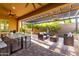 Outdoor patio with pergola and a ceiling fan, featuring dining and seating areas with serene backyard views at 13448 W Miner Trl, Peoria, AZ 85383