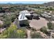 Aerial view showcasing a desert home with a large driveway, three-car garage, and solar panels at 13931 E Via Linda --, Scottsdale, AZ 85259