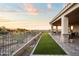 Landscaped backyard with a covered patio, artificial turf, and wrought iron fencing overlooking beautiful desert scenery at 13931 E Via Linda --, Scottsdale, AZ 85259