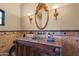 Charming bathroom featuring a unique copper sink, decorative mirror, and stone tiling at 13931 E Via Linda --, Scottsdale, AZ 85259