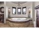 Spa-like bathroom featuring a large soaking tub, chandelier, and arched windows for natural light at 13931 E Via Linda --, Scottsdale, AZ 85259
