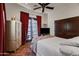 Comfortable bedroom featuring a bed, patio doors with red curtains, and tile flooring at 13931 E Via Linda --, Scottsdale, AZ 85259