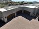 Aerial view of a large three-car garage with brick driveway, solar panels, and rustic doors at 13931 E Via Linda --, Scottsdale, AZ 85259
