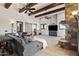 Bright living room with wood beams, a stone fireplace, and a large sectional sofa at 13931 E Via Linda --, Scottsdale, AZ 85259
