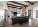 Open living room featuring travertine flooring, stone fireplace, wood beams, and large windows with desert views at 13931 E Via Linda --, Scottsdale, AZ 85259
