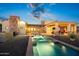 Inviting backyard featuring a long pool with fountain features, covered patio, and lush desert landscape at 13931 E Via Linda --, Scottsdale, AZ 85259