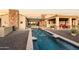 Backyard oasis showcasing a sparkling pool with water features, lush landscaping, and a cozy covered patio at 13931 E Via Linda --, Scottsdale, AZ 85259