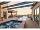 Beautiful outdoor living space featuring a pool, spa, covered patio, and outdoor kitchen with desert views at 13931 E Via Linda --, Scottsdale, AZ 85259