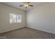 Neutral bedroom features plush carpet, ample natural light from the window, and ceiling fan at 15364 W Acapulco Ln, Surprise, AZ 85379