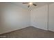 Cozy bedroom featuring carpeted floor, a ceiling fan, and a door, for comfort and privacy at 15364 W Acapulco Ln, Surprise, AZ 85379