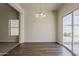 Bright dining area with wood-look floors, modern chandelier and view to the backyard through sliding glass door at 15364 W Acapulco Ln, Surprise, AZ 85379