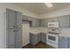 Efficient kitchen features stainless steel appliances, ample grey cabinetry, and light countertops for modern living and storage at 15364 W Acapulco Ln, Surprise, AZ 85379