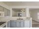 Modern kitchen with grey cabinets and light countertops, open to the living area, creating a seamless and social cooking experience at 15364 W Acapulco Ln, Surprise, AZ 85379