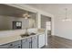 Open kitchen with light countertops and grey cabinets offers a seamless connection to the living and dining areas at 15364 W Acapulco Ln, Surprise, AZ 85379