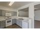 Bright kitchen features stainless steel appliances, grey cabinets, and light countertops with open access to the adjacent room at 15364 W Acapulco Ln, Surprise, AZ 85379