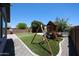 Spacious backyard with a playground, well-maintained artificial grass, and easy-care desert landscaping at 16475 N 183Rd Dr, Surprise, AZ 85388