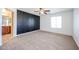 Bedroom with an accent wall, neutral carpet, a ceiling fan, and an adjoining bathroom for added convenience at 16475 N 183Rd Dr, Surprise, AZ 85388