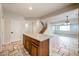 Kitchen island with wood cabinets and travertine flooring, open to the dining and living areas at 16475 N 183Rd Dr, Surprise, AZ 85388