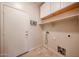 Functional laundry room with overhead cabinets, a utility sink, and travertine tile flooring at 16475 N 183Rd Dr, Surprise, AZ 85388