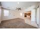 Bright living room featuring neutral walls, a ceiling fan, and tile flooring leading into the open kitchen at 16475 N 183Rd Dr, Surprise, AZ 85388